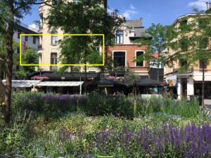een gele rechthoek midden in een tuin met bloemen bij The National Lodge in Antwerpen