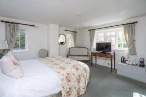 a bedroom with a bed and a desk and a television at Chequers Hotel in Pulborough