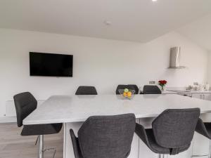 基拉尼的住宿－Coolnaharragill Lower，白色的餐桌、椅子和电视