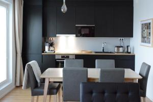 una cucina con mobili neri, tavolo e sedie di Riverside Lux with 2 bedrooms, Car Park garage and Sauna a Turku