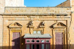 a brick building with sculptures on the side of it at Valletta 2 bedroom sleeps 6 apartment walking distance to centre and the sea in Valletta