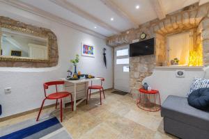 a living room with a table and two red chairs at Apartment Neva in Dubrovnik