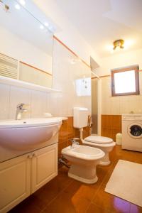 ein Badezimmer mit 2 WCs, einem Waschbecken und einem Spiegel in der Unterkunft Apartman M&M Žminj in Žminj