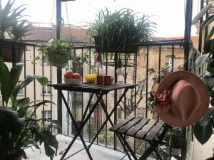 una mesa y una silla en un balcón con plantas en Pied à Terre Sant'Agostino, en Milán