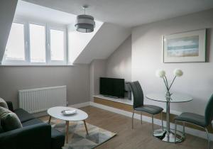 - un salon avec un canapé et une télévision dans l'établissement Alpha Spa classic 1 bedroom apartment, à Harrogate