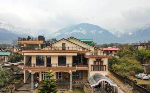 ein großes Haus mit Bergen im Hintergrund in der Unterkunft Touristen Holiday Home A luxury Villa in Dharamshala
