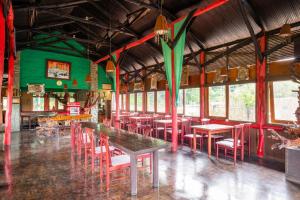 a restaurant with tables and chairs and green walls at Capital O 2640 Rumah Kayu Cottage Syariah in Batureo 1