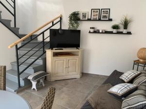 a living room with a television on a stand with a staircase at Solimany in Saint-Gilles