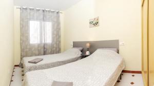 twee eenpersoonsbedden in een kamer met een raam bij La Mata Beach Resort in La Mata