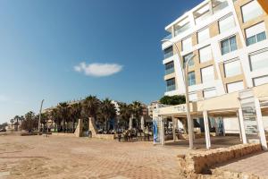 een gebouw op het strand met palmbomen op de achtergrond bij La Mata Beach Resort in La Mata