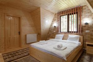 a bedroom with a large bed in a wooden room at Centrul de Echitatie Poiana Brasov in Poiana Brasov