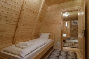 ein Schlafzimmer mit einem Bett in einer Holzhütte in der Unterkunft Centrul de Echitatie Poiana Brasov in Poiana Brașov