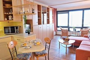 eine Küche und ein Wohnzimmer mit einem Tisch und Stühlen in der Unterkunft BRN Meeresblick in Laboe