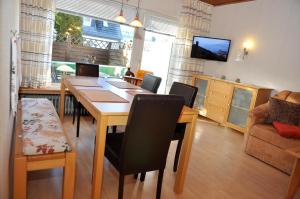 a dining room with a table and chairs and a television at Johanna in Laboe