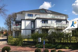 Un grand bâtiment blanc avec un homme dessus dans l'établissement Sommerbrise Wallbox, à Laboe