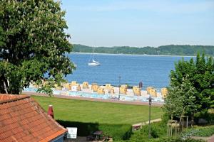 uma piscina com cadeiras e um barco na água em Treibgut em Laboe