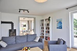 a living room with a blue couch and a chair at Strandhaus 19b in Laboe