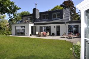 a house with a patio and a lawn at Villa Bellevue I in Heikendorf