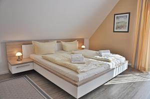 um quarto com uma grande cama branca e 2 almofadas em Bounty em Laboe