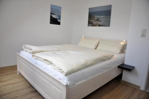 uma cama branca com lençóis brancos e almofadas em PW Yorikke em Laboe