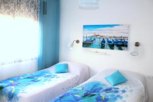 een slaapkamer met 2 bedden en een schilderij aan de muur bij Cosmo Grey in Hospitalet de Llobregat
