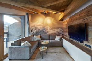 Venediger Lodge في نيوكيرشين آم غروسفينديغر: غرفة معيشة مع أريكة وتلفزيون