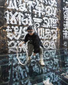 um homem de pé em cima de um chão de vidro em frente a uma parede em WYNWOOD Hotel em São Petersburgo