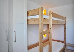 Etagenbett in einem Zimmer mit einer Leiter in der Unterkunft Kapitänshaus 12 in Laboe
