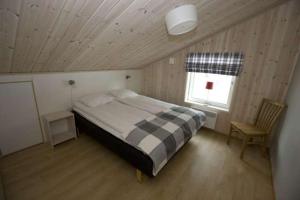 a bedroom with a bed and a window and a chair at Leksand Strand Camping och Resort in Leksand