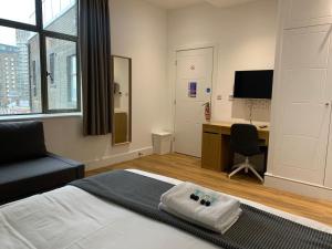 a bedroom with a bed and a desk with a computer at London City View in Woolwich