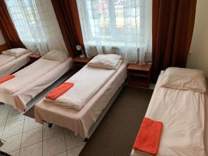 een kamer met 3 bedden en een raam bij Hotel Turystyczny in Białystok