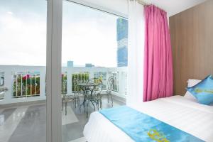 a bedroom with a bed and a balcony with a table at QUE HUONG HOTEL in Quy Nhon +42 photos