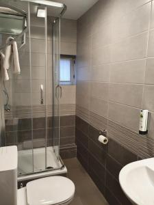 y baño con ducha, aseo y lavamanos. en Hotel Piano 2 - Mont-St-Guibert - Louvain-la-Neuve, en Corbais