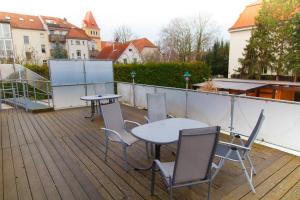 een terras met een tafel en stoelen bij Hotel am Gutspark in Leipzig