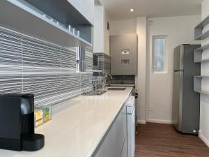 a kitchen with white counters and stainless steel appliances at Departamento nuevo y luminoso en el centro de BA in Buenos Aires