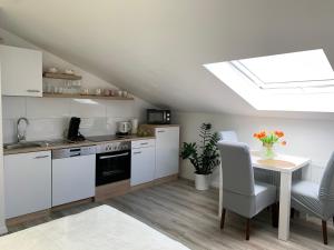 a kitchen with white cabinets and a table and chairs at Prime Host apartments in Karlsruhe