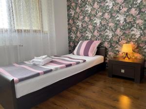 um quarto com uma cama com papel de parede rosa e roxo em Gloria em Olomouc