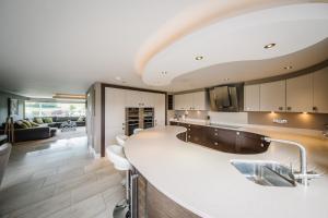 a large kitchen with a large white counter top at Carus House @ Carus Green in Kendal