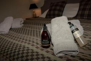 a bottle of alcohol and towels on a bed at Albatross B&B Dornoch in Dornoch +32 photos