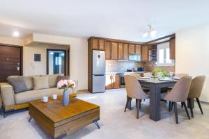 a kitchen and living room with a table and a couch at SYKA Thassos - Apartment down floor SKALA RACHONIOU in Skala Rachoniou