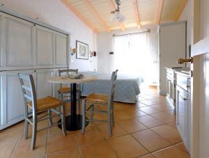 a kitchen with a table, chairs and a refrigerator at Baia Caddinas Clubresidence in Golfo Aranci