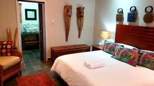 a bedroom with a bed and some items on the wall at Khayamanzi Guesthouse in Hartbeespoort