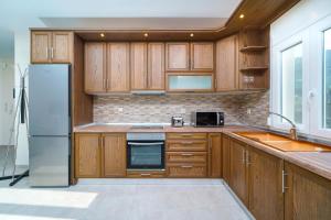 una cucina con armadi in legno e frigorifero di Skala Rachoni Cris Luxury Apartment Upper Floor a Skala Rachoniou