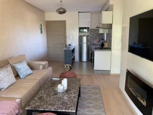 una sala de estar con un sofá y una mesa en Marrakech Prestigia Jade Golf Piscine, en Marrakech