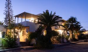 a house with a palm tree in front of it at Margarita Apartments in Ierapetra