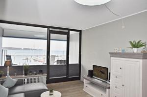 a living room with a couch and a large window at BRN Fliegender Hollaender in Laboe