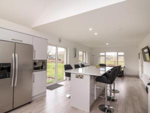 uma cozinha com armários brancos e uma ilha de cozinha com electrodomésticos pretos em Coolnaharragill Lower em Killarney