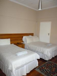 a hotel room with two beds with white sheets at Royal Guest House in East London