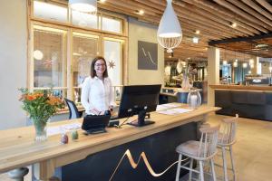 une femme debout au comptoir d'un magasin dans l'établissement Venediger Lodge, à Neukirchen am Großvenediger