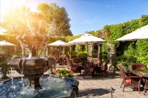 uma fonte num pátio com mesas e cadeiras em Auberge Godefroy em Bécancour